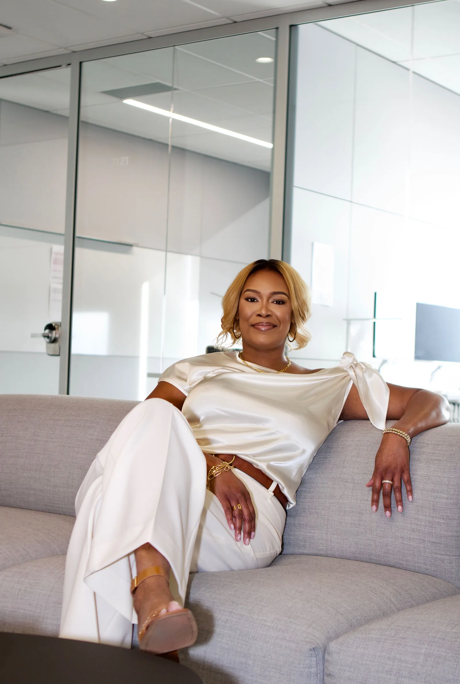 Darice Rene seated on a sofa in a bright office