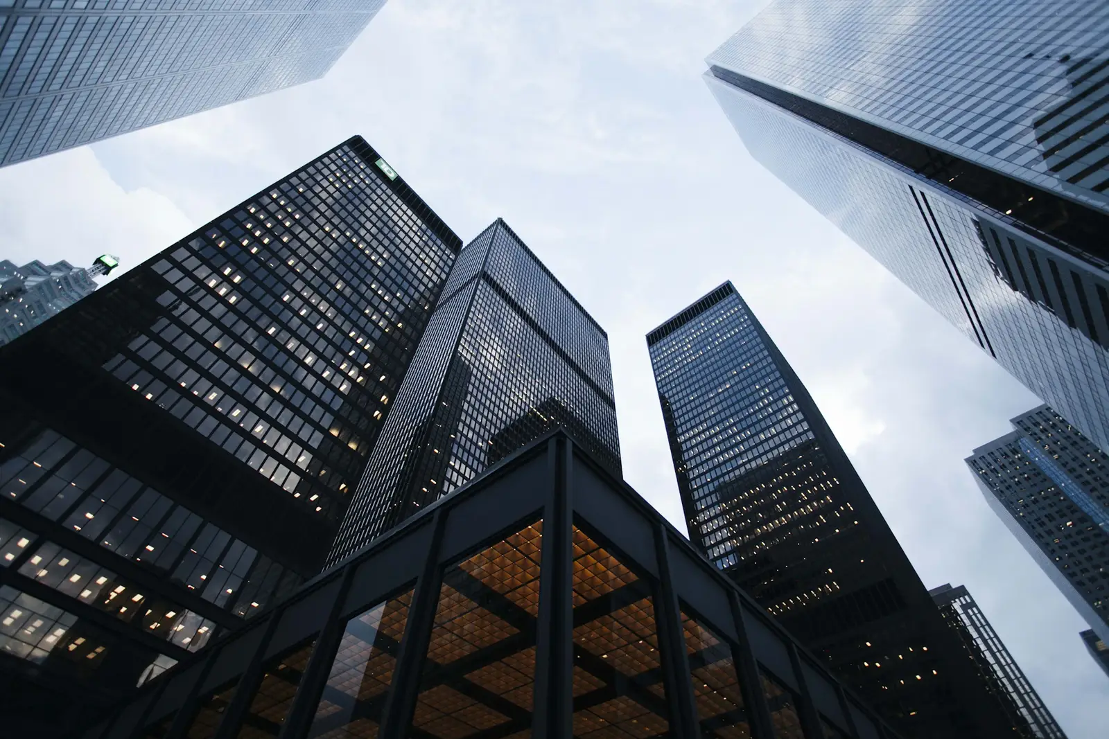 Mixed-use downtown buildings rising around a warm illuminated entrance