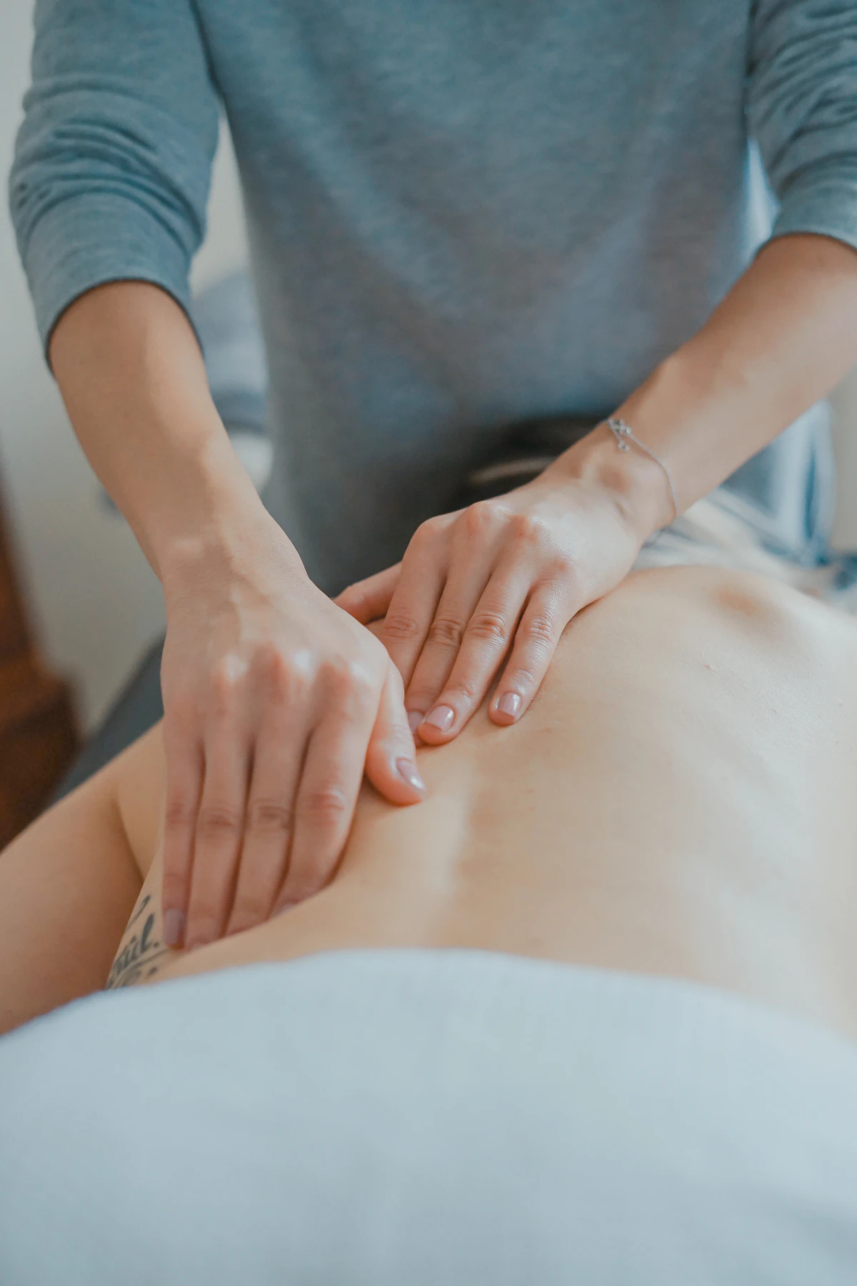 Wellness treatment room with hands giving a warm therapeutic massage